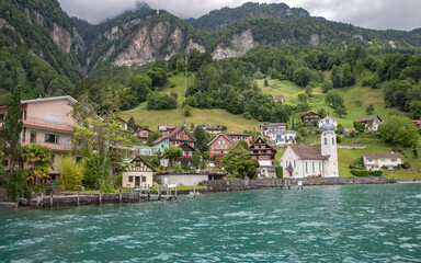 Fototapeta na wymiar View of mountain, lake and old town of Sisikon in Switzerland