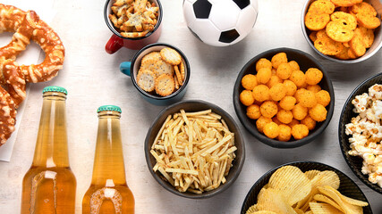 Beer bootles,  snacks and ball on  table.