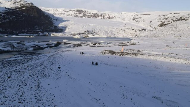 Aerial tracking shot of parachuters walking to meet up with their team in Iceland