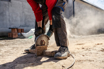 Cropped picture of a housebuilder cutting bricks with grinder at construction site.