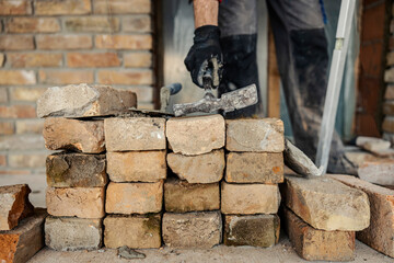Close up of a hosuebuilder taking a hammer for building a house.