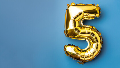 Banner with number 5 golden balloon with copy space. Five years anniversary celebration concept on a blue background. © Uuganbayar