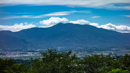 夏に鞍手町の剣岳山頂から蒼くかすむ福智山を望む