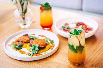 a full table of food and soft drinks at the summer cafe. second courses with refreshing drinks in a coffee shop