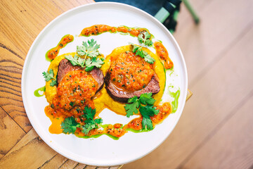 two pieces of beef chop with sauce in a cafe. beef cuts of meat with tomato sauce in a restaurant