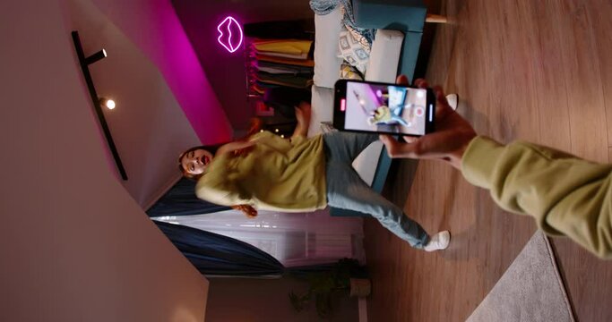 Asian girl recording video of trending hip hop dance challenge for likes and followers on social media platform, vertical video. Video of trending dance challenge for likes and followers tik tok reels