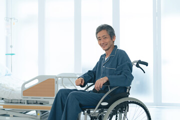 Fototapeta na wymiar 車椅子に座って笑顔のシニア男性