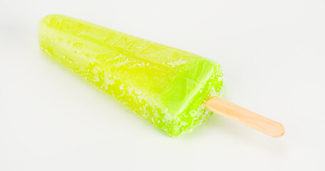 Lime-flavored popsicle lies on a white background.