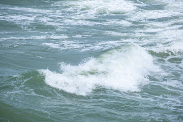 Sea waves. Nature by the beach and the sea in summer with soft sunlight. Sandy beach, sparkling sea against the blue sky.	