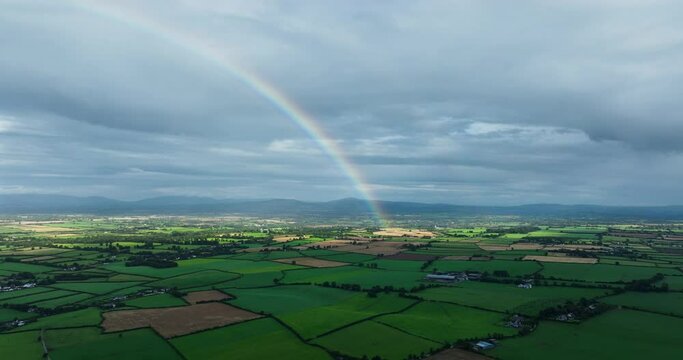 A huge rainbow against the green fields of Ireland 4k