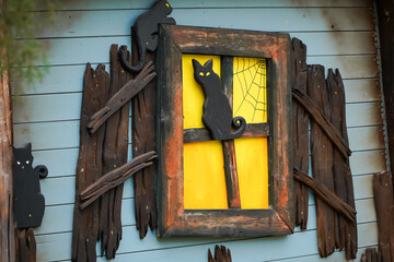 Halloween decoration on the wall of a house. the cat at the window.