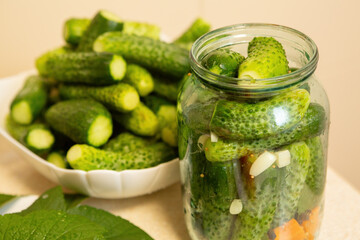 Homemade cucumbers prepared for canning, stacked in a jar and plate