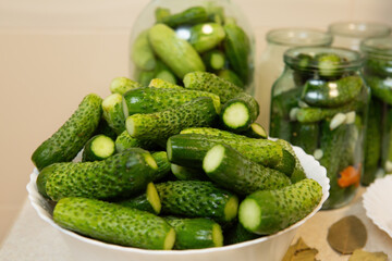 On the table are jars and plates of fresh pickles