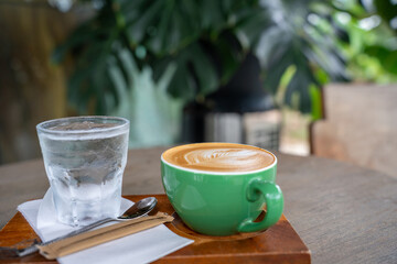 Hot coffee latte a cup of coffee cupucino on wood table background with warm morning sunlight concept lifestyle before working , Start day by coffee