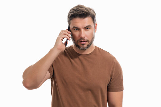 Handsome Man In T-shirt Using Mobile Phone Isolated On Studio Background. Portrait Of Confidence Middle Aged Millennial Hispanic Man Using Cellphone. Guy With Smartphone Isolated Studio Background.