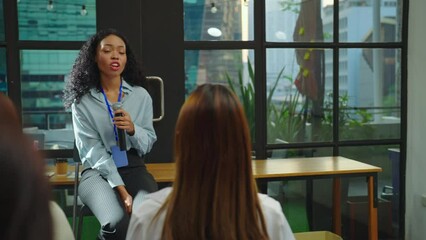 Beautiful young woman talking with team at meeting room. She sharing about business project with team.