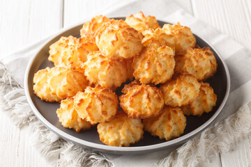 Natural baked coconut cookies or coconut macarons closeup on the plate on the table. Horizontal