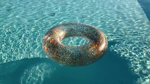 Round inflatable floats in pool clear water. Transparent waters with round inflatable. Inlatable in the shape of a donut in the pool