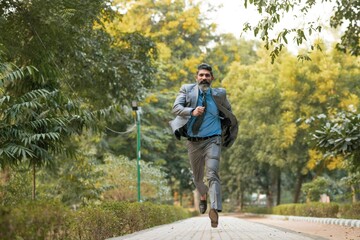 Obraz premium Indian corporate man running at park.