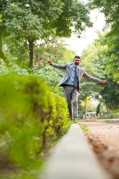 Indian businessman walking at park and giving happy expression