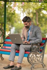 Indian businessman working on laptop at outdoor