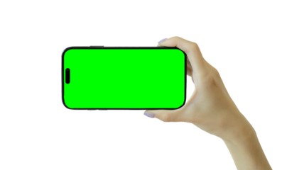 Hand holding smartphone with green screen isolated on transparent background cutout, PNG file. Mockup template for artwork design.