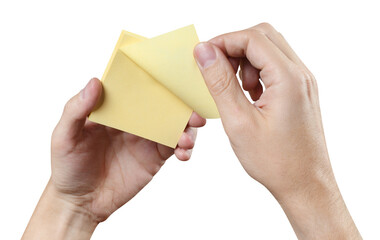 Hands holding a stack of yellow stickers, cut out