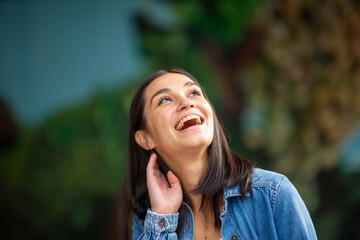 Naklejka premium Close up happy young woman laughing and looking up