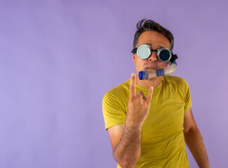 Man with cyberpunk glasses and snorkel dressed in brightly colored clothes interacting with his hands.