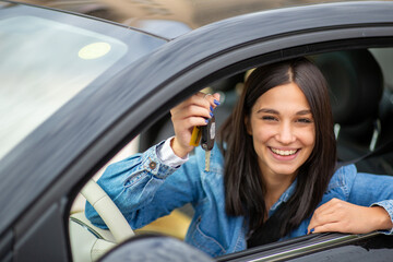 smiling young woman with car keys in hand
