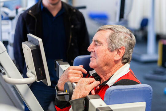 man in his sixties at physios using exercise therapy equipment