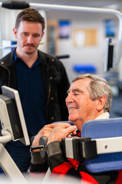 exercise therapy equipment at physiotherapy clinic with smiling man in his sixties