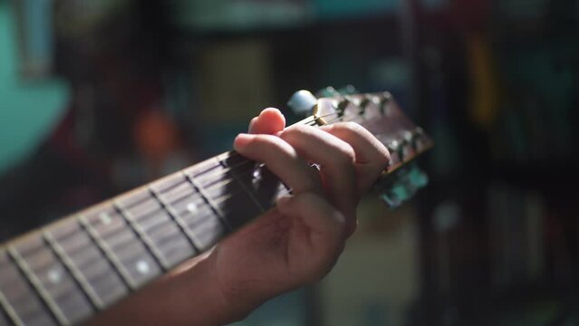 The close-up image of playing a guitar chord in acoustic style
