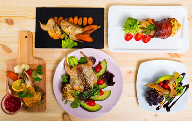 Top view of set of dishes from small fowls with vegetables on wooden background..