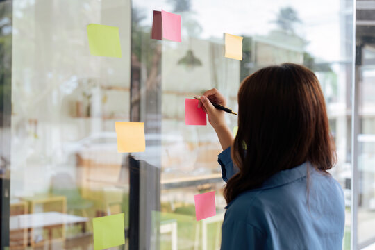 Thoughtful Woman Hand Writing Paper Note, Sticky Note On Glass Window