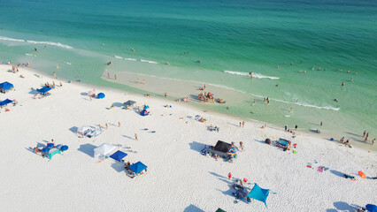 Beautiful sugar-white sand beaches and row of beach umbrella with family people gathering, relaxing, swimming on turquoise water, gorgeous shade blue waves in South Walton, Florida, USA