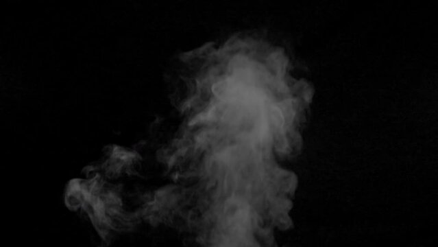 White smoke,steam on a black background. Slow motion. Shot in 4K resolution at 60fps.