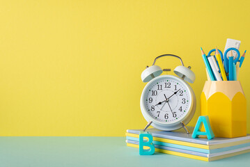 Back to school concept. Photo of school supplies on blue desktop alarm clock stack of notebooks...
