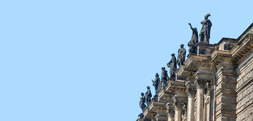 Old roof statutes of high ranked priests, saints, artists, phylosophers lined up in the city opera...