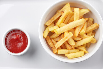 French fries with ketchup on a white plate. Close-up