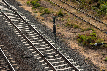 Obraz premium Contact wire, insulator and railroad tracks. Technology, railroad ties and transportation.
