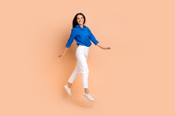 Fototapeta na wymiar Full length photo of positive girl wear blue stylish smart casual clothes go store mall empty space isolated on beige color background