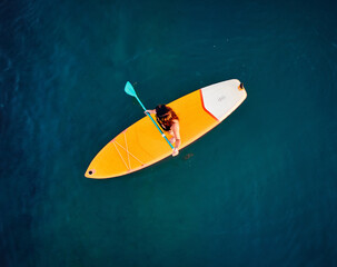 Aerial of woman at Sup board at lake