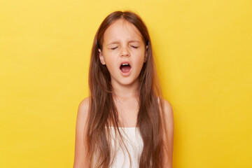 Harmful little girl with ponytails standing isolated over yellow background screming with closed eyes expressing negative emotions. - obrazy, fototapety, plakaty