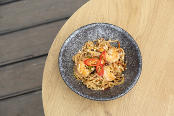 Udon noodles with shrimp and fried vegetables in a bowl