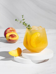 Peach thyme spritzer cocktail on a light background. Vertical photo. Copy space. hard light.