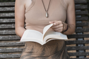 natural woman in hat reading a book in nice sunny green natural environment