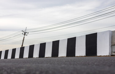 Close-up view of low angle concrete barriers painted in black and white painted.