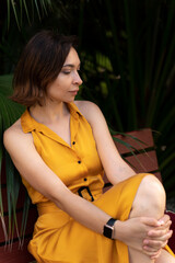 Attractive woman in yellow dress sitting