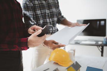 The home design architects are reviewing the house plan draft, the project commissioned by the client, and the custom design before delivery. Interior design and decoration ideas.